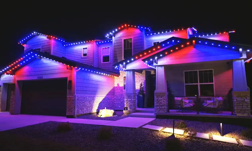 Modern two-story home at night with permanent lighting along every eave